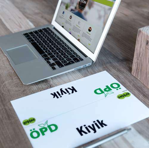 Ausgedruckte Zellux-Unterlagen neben einem Laptop